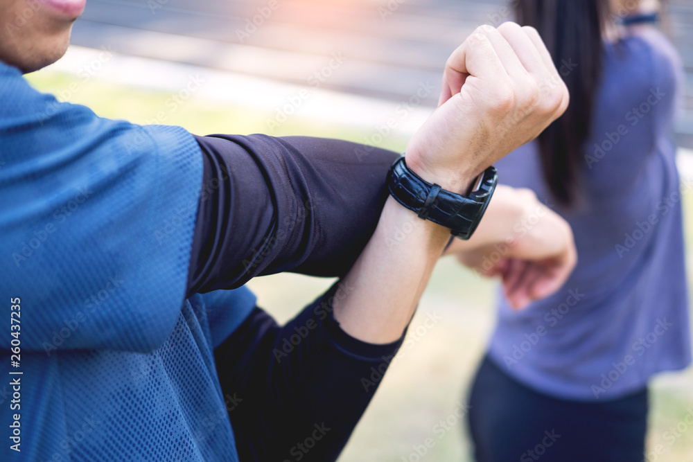Fototapeta premium Early morning workout, Fitness couple stretching outdoors in park. Young man and woman exercising together in morning, Living healthy lifestyle fitness, sport concept.