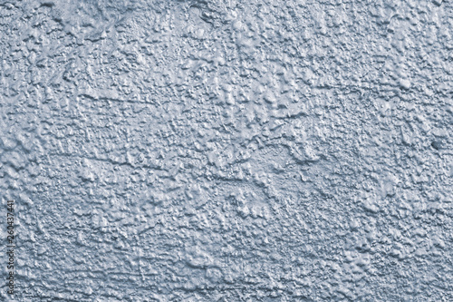 Rough concrete wall painted silver blue. Silver texture of concrete wall close-up. Silver gloss background of uneven concrete wall. Blue cement wall texture background.