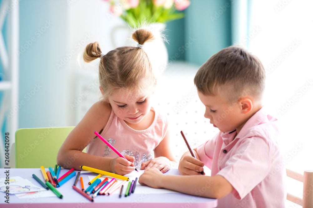 Little children play and draw with colorful pencils Little children play and draw with colorful pencils