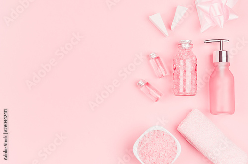 Spring fresh cosmetic products for makeup and bath in pastel pink color as decorative border, top view.