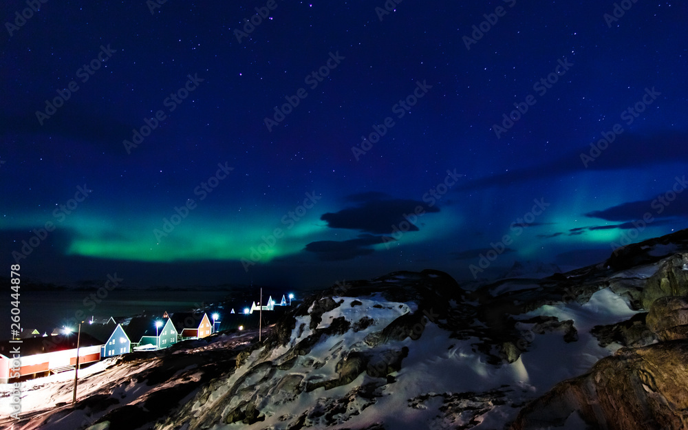 Northern lights over the Inuit village, fjord and mountains, nearby Nuuk city, Greenland