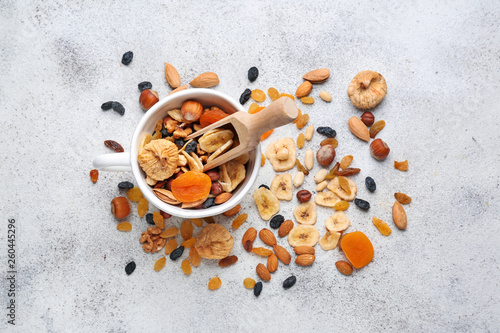 Cup and scoop with assortment of tasty dried fruits and nuts on table