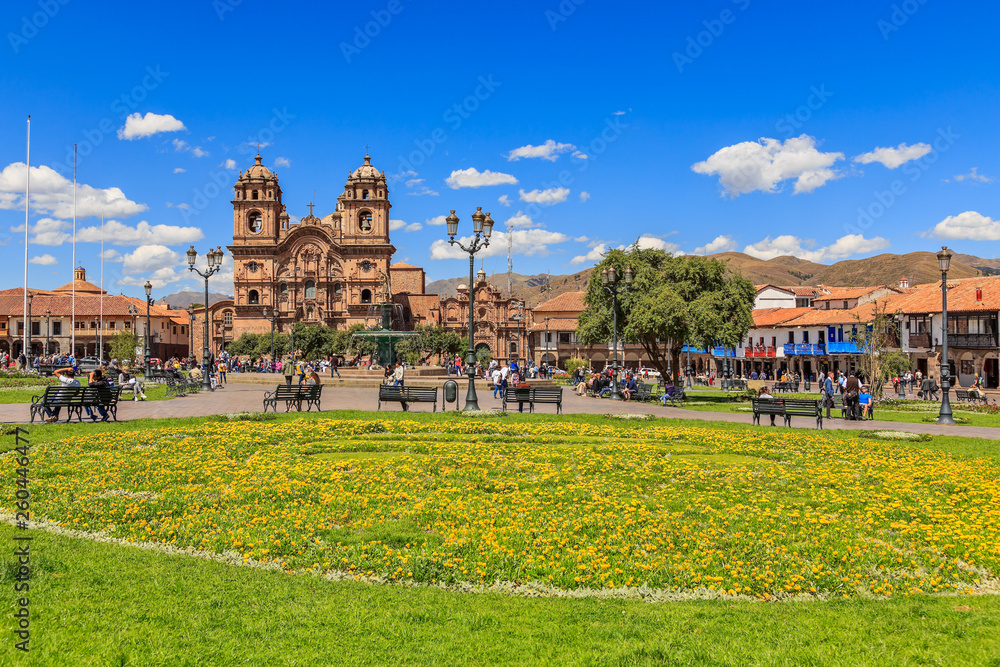 Fototapeta premium Plaza de Armas main square with cathedral and yellow flowers in foreground, Cuzco, Peru
