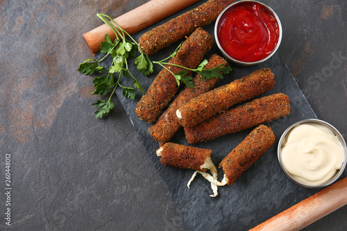 Obraz na plátně Tasty mozzarella sticks with sauces on table