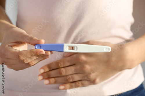 Woman with pregnancy test, closeup