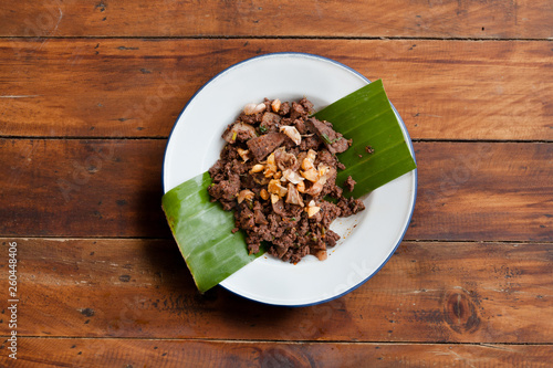 Obraz na plátně Thai street food Larb moo or Spicy minced pork on white plate and wood backgroun
