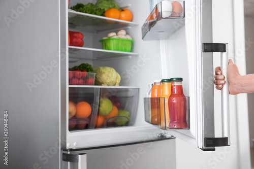 Woman opening modern fridge