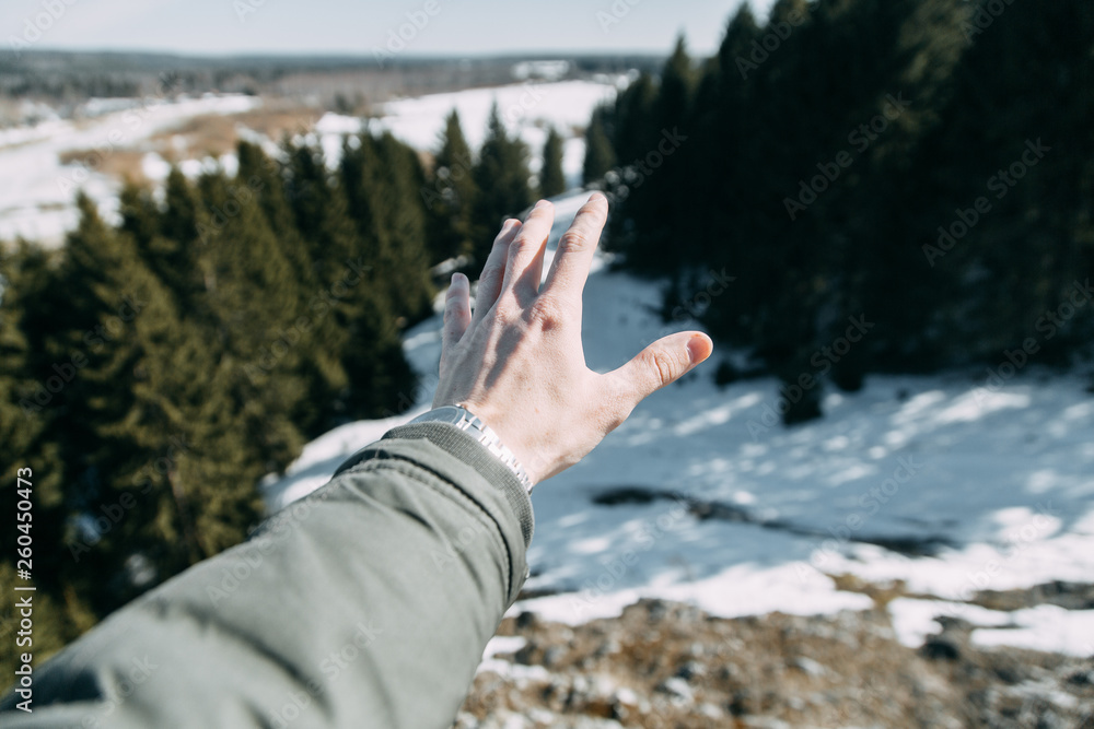 Winter travel and nature. A young blogger sits and stands on a mountain with a beautiful view.