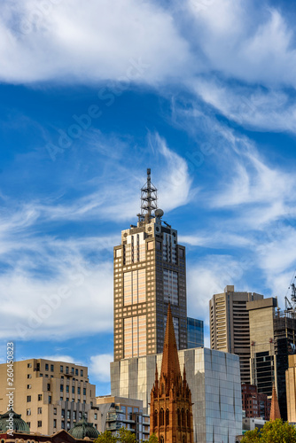 A Melbourne city skyscraper in the late afternoon sun with dramatic white clouds