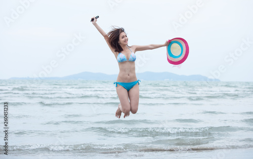 tourist girl in bikini jumping playing relaxation on the sand beach summer holiday concept