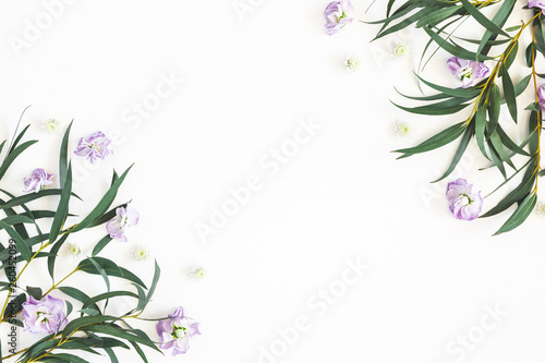 Flowers composition. Purple flowers and eucalyptus leaves on white background. Flat lay, top view, copy space
