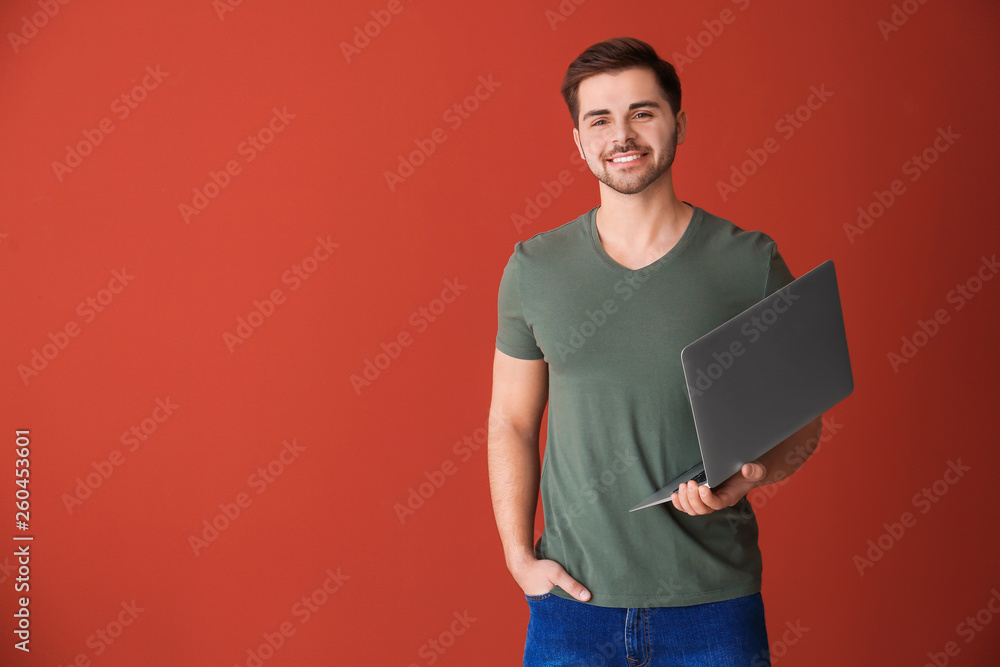 Male programmer with laptop on color background Male programmer with laptop on color background