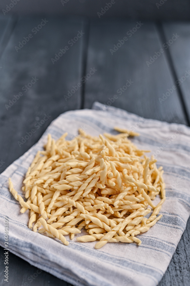 Dark photo of homemade pasta Trofie from Liguria . Italian healthy food concept with copy space. Soup with homemade pasta and meat Dark photo of homemade pasta Trofie from Liguria . Italian healthy food concept with copy space. Soup with homemade pasta and meat