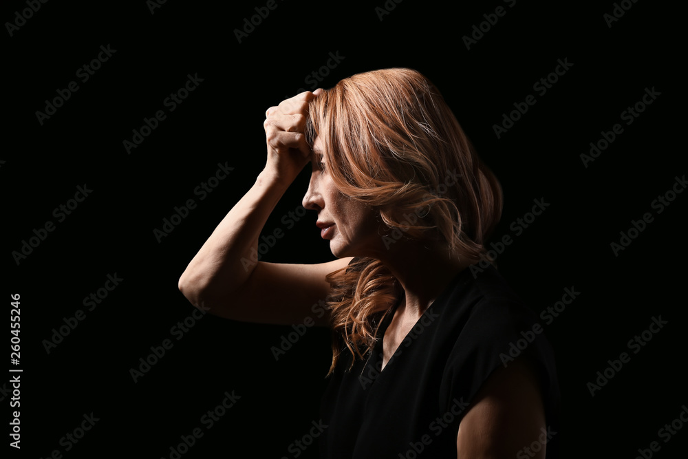 Obraz premium Mature woman suffering from headache on dark background