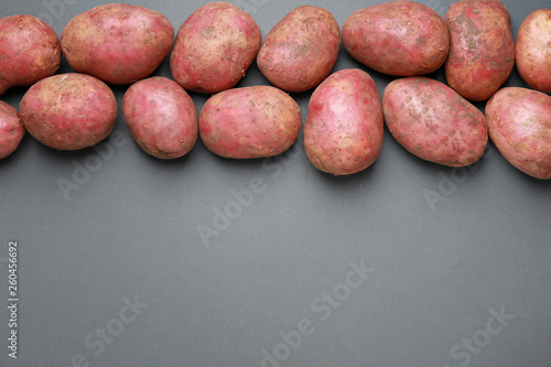Raw potato on grey background