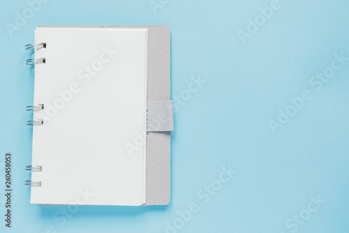 Clean spiral note book for notes and messages on blue background. Minimal business flat lay