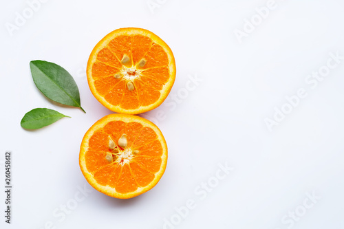 Orange fruit with green leaves on white