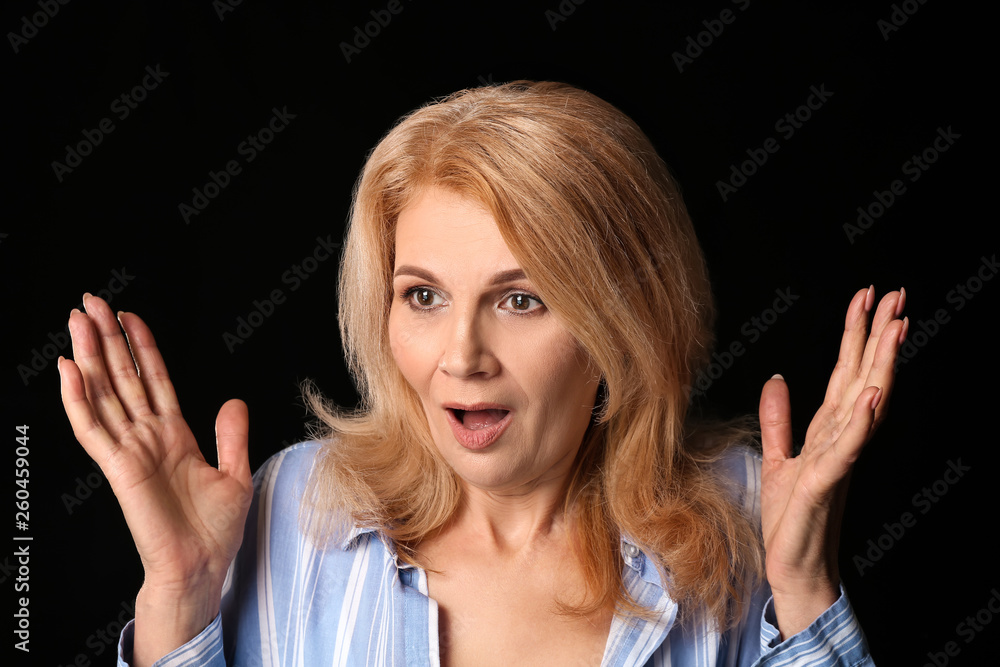 Surprised mature woman on dark background Surprised mature woman on dark background