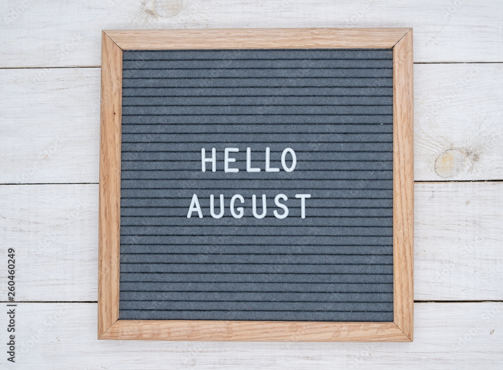 English text Hello August on a letter Board in white letters on a gray background