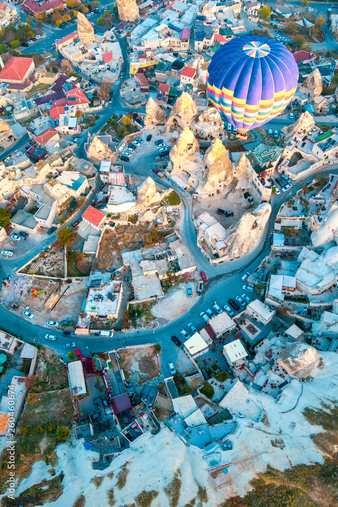 Hot air balloon flying at dawn over the city of Cappadocia in Turkey. View from above.