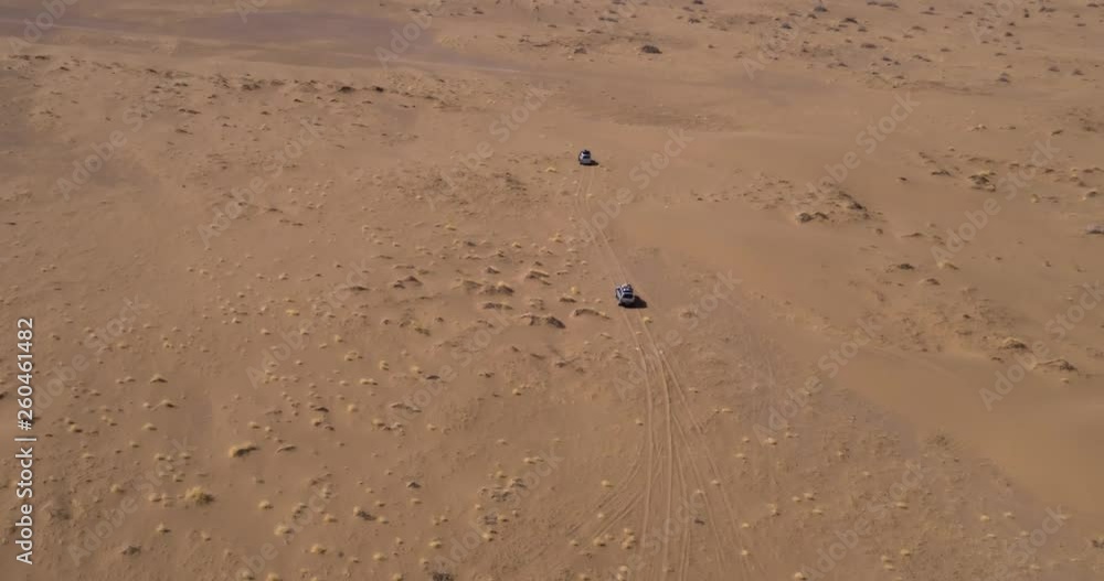 Shooting from the air the car moving through the desert. Desert safaris across sand dunes. Shooting from the air the car moving through the desert. Desert safaris across sand dunes.