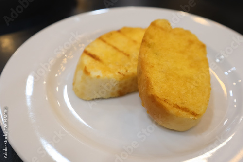 Garlic breads on the white cearamic plate.