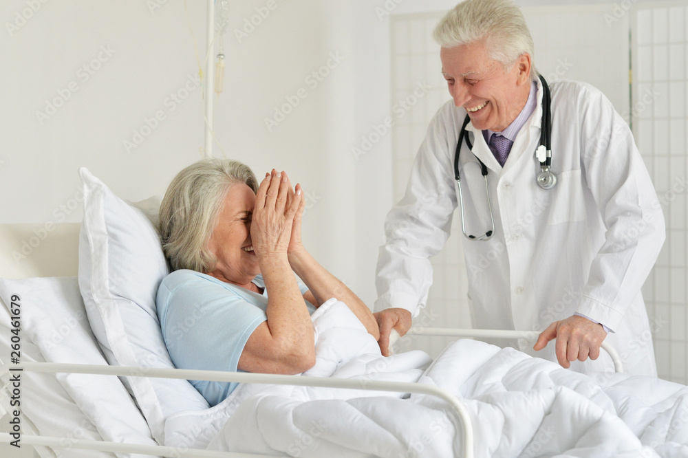 Fototapeta premium Portrait of happy senior woman in hospital with caring doctor