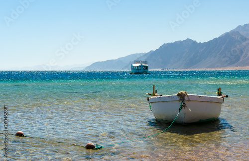 old wooden fishing boat in the sea against the backdrop of the high rocky mountains in Egypt Dahab