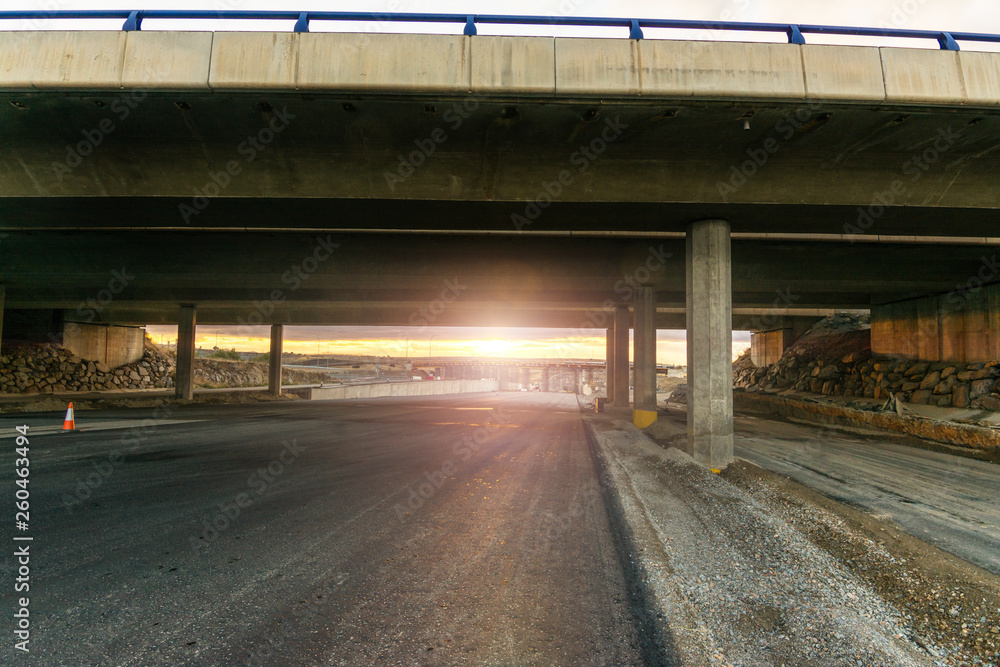 Newly paved highway under the construction of a bridge Newly paved highway under the construction of a bridge