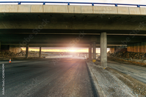 Newly paved highway under the construction of a bridge