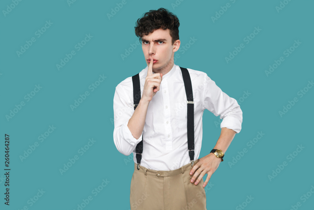 Serious man showing silent sign and looking at camera. Serious man showing silent sign and looking at camera.