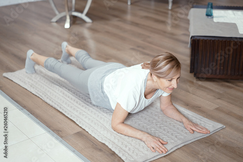 Beautiful mature woman stands in plank position