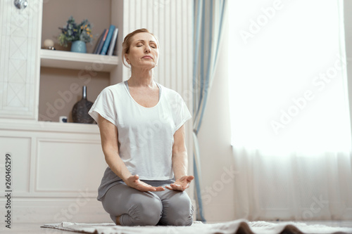 Fototapeta Naklejka Na Ścianę i Meble -  Attractive mature woman is practicing yoga in peace