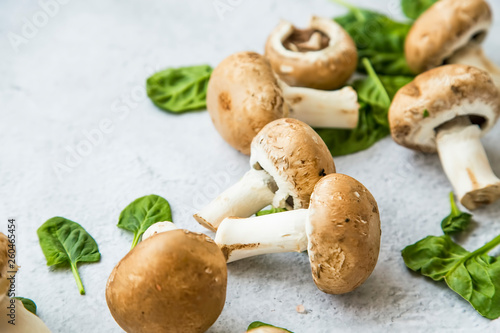Champignon mushrooms closeup with spinach leaves, still life, healthy organic food vegetables