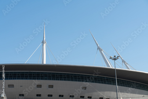 white metal construction on the roof of the stadium against the blue sky © vladimir