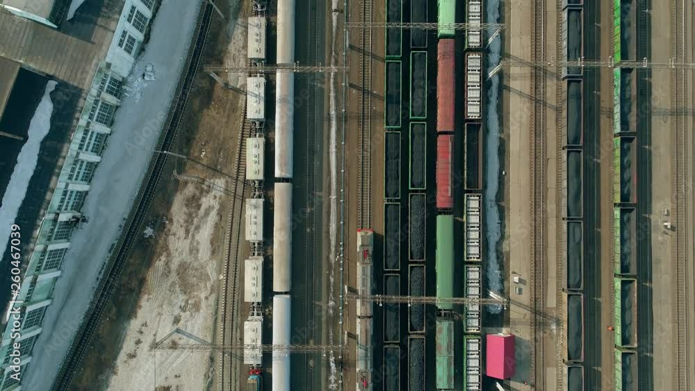 On the railroad tracks a passenger train rides in slow motion. Aerial fly from train tracks on railway. On the railroad tracks a passenger train rides in slow motion. Aerial fly from train tracks on railway.