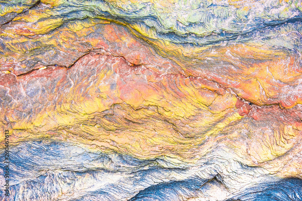 Colourful mosaics or rocks - layered sedimentary minerals exposed by sea - textured background
