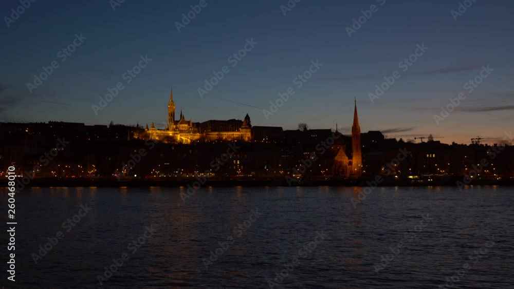 Matthias church in Budapest, illuminated at night with Danube river in the foreground Matthias church in Budapest, illuminated at night with Danube river in the foreground
