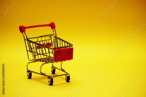 Mini trolley cart on yellow background