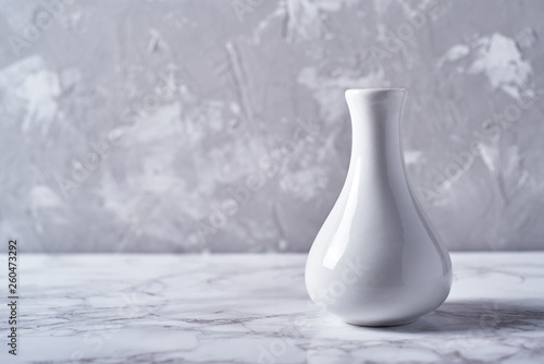 Cuadro en lienzo White vase isolated on plaster grey wall background, copy space
