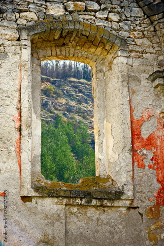 View of the mountain landscape through the window of an old dilapidated synagogue. Old masonry walls. Lack of roof. Mountains, forest, ruins. Rashkov, Moldova. photo