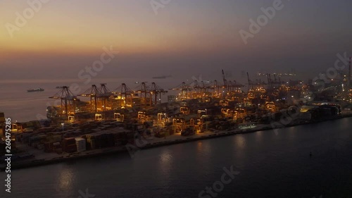 Aerial shoot of landscape with cargo terminal and city in Shenzhen,China. containers and cranes in the dock.lights on  in the eveninng. photo