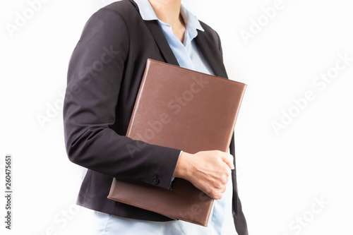 Young woman in a business suit holding a file or a binder.