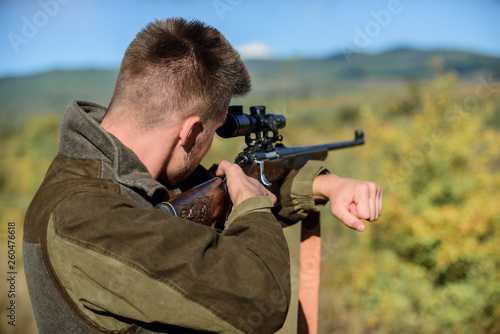 Man aiming target nature background. Aiming skills. Hunter hold rifle aiming. On my target. Bearded hunter spend leisure hunting. Hunting optics equipment for professionals. Brutal masculine hobby
