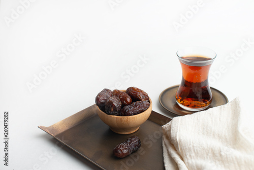 Ramadan Kareem Festival, Dates on wooden bowl with cup of black tea and rosary on white isolated background