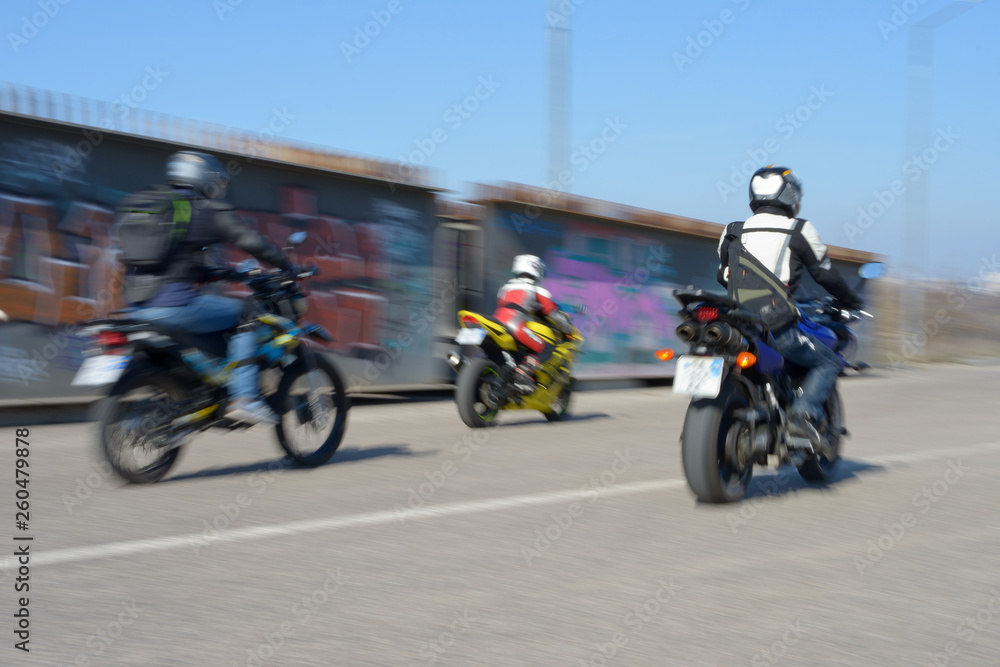 Very fast bikers ride down the road