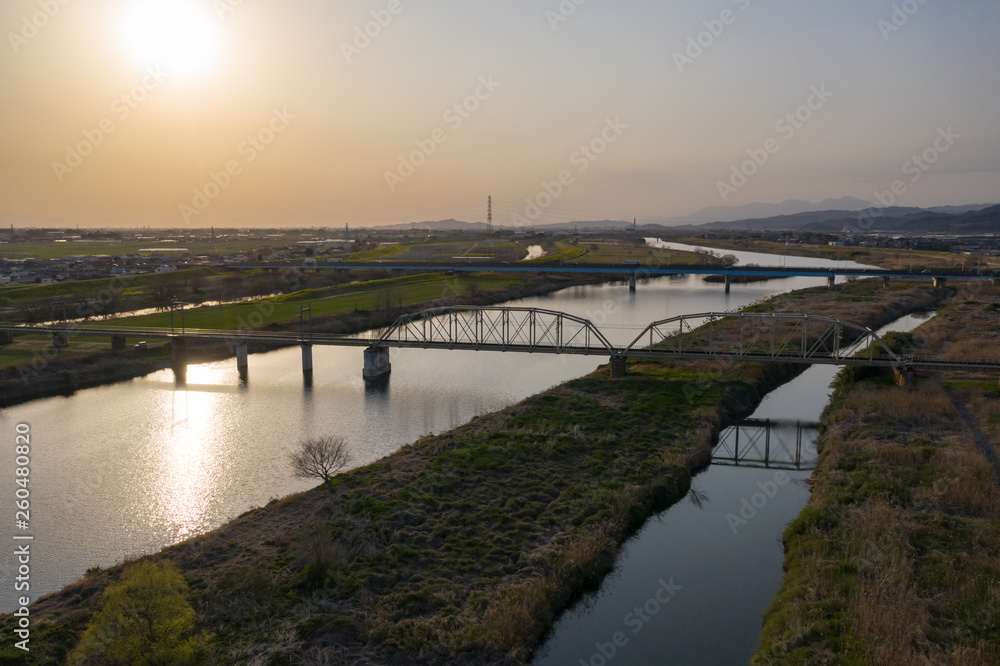 夕暮れの渡良瀬川とローカル列車