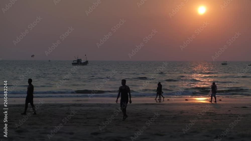 Silhouette of guys playing football on the beach while the sun is setting behind them in the Arabian sea with a ship and some small boats as seen from a beach in Goa, India Silhouette of guys playing football on the beach while the sun is setting behind them in the Arabian sea with a ship and some small boats as seen from a beach in Goa, India