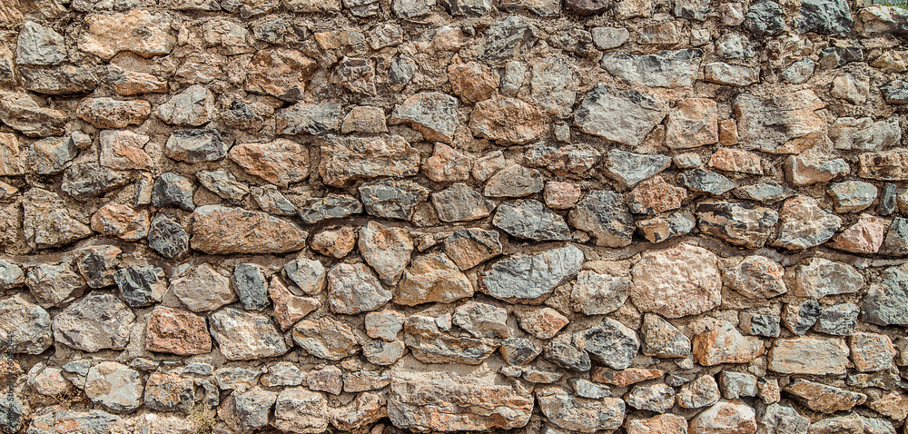 Texture of old stone wall. Surface from grey and orange rocks. Ancient wall in Macedonia Texture of old stone wall. Surface from grey and orange rocks. Ancient wall in Macedonia