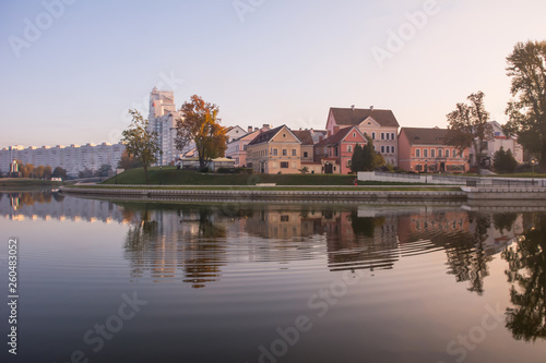 Minsk, Belarus. Gentle dawn. Trinity suburb is reflected in the river Svisloch. Ducks swim in the river.
